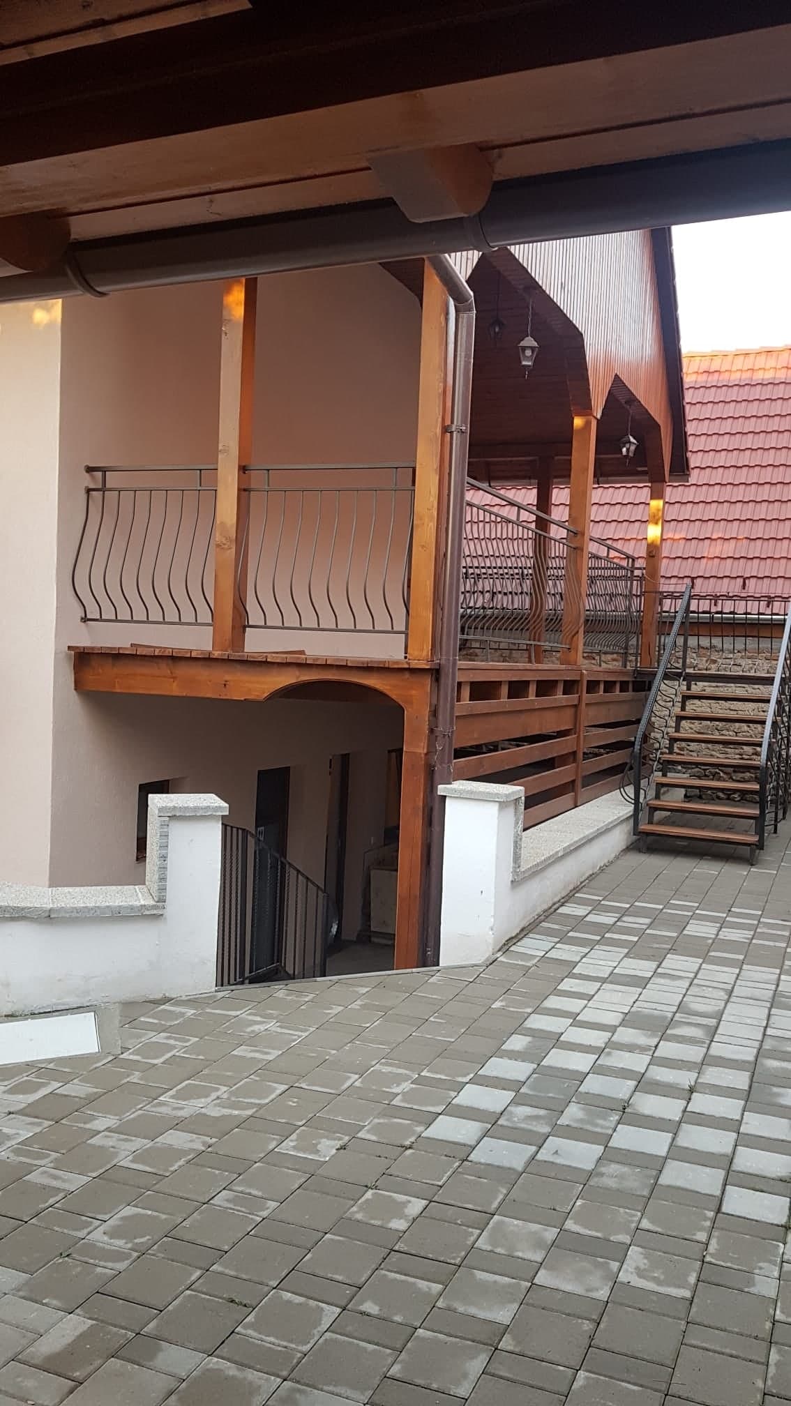 Colț al curții cu scara exterioară din lemn spre balcon